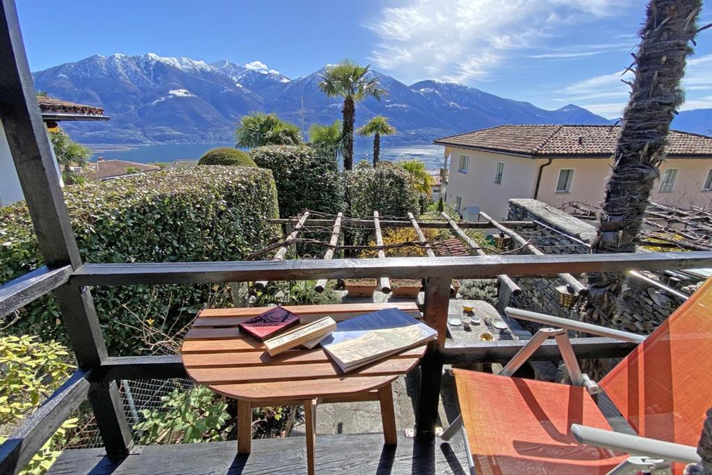 a table and chairs on a balcony with mountains at Rustico Luna by HolAp SA in Brione sopra Minusio