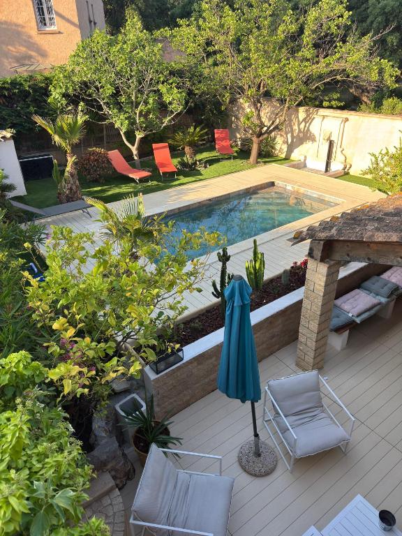 - une piscine avec des chaises et un parasol sur la terrasse dans l'établissement Villa Domaine Font Mourier, à Cogolin