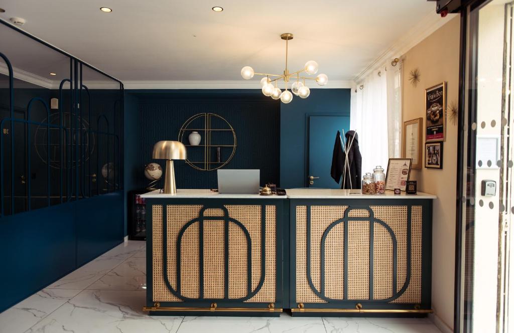 a room with blue walls and a table with a laptop at La Caravelle in Aix-en-Provence