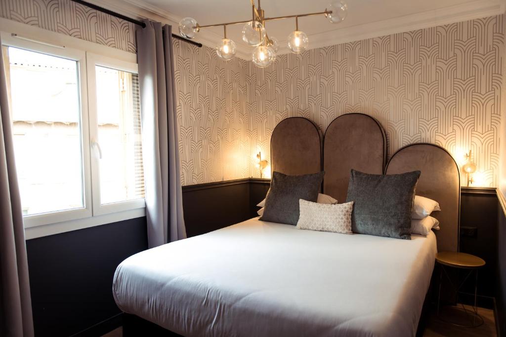 a bedroom with a large bed with two pillows at La Caravelle in Aix-en-Provence