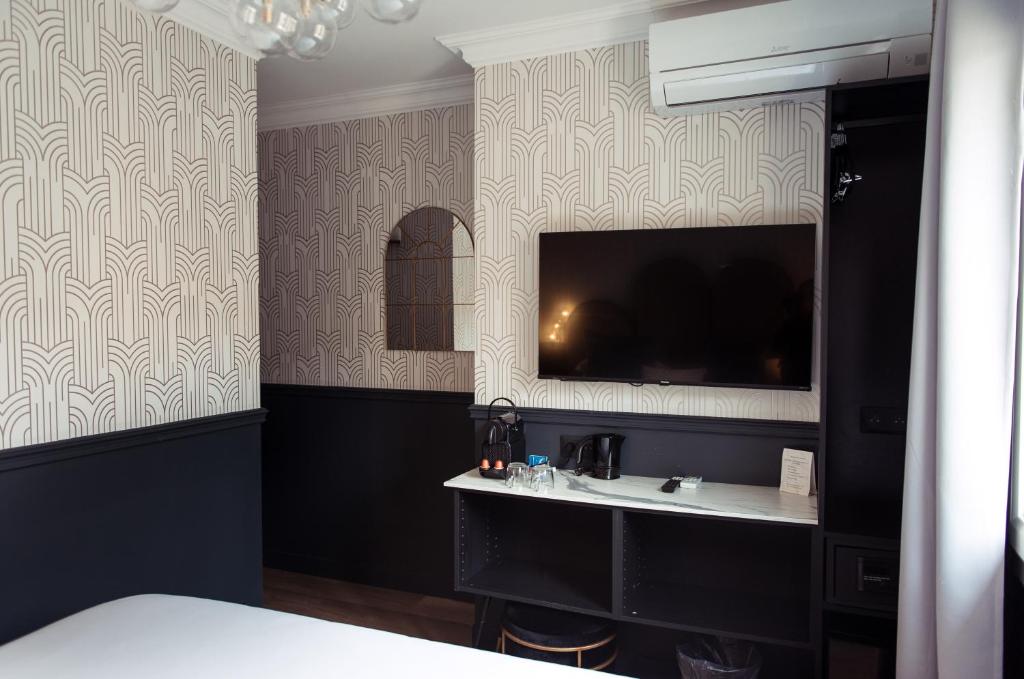 a bedroom with a sink and a tv on the wall at La Caravelle in Aix-en-Provence