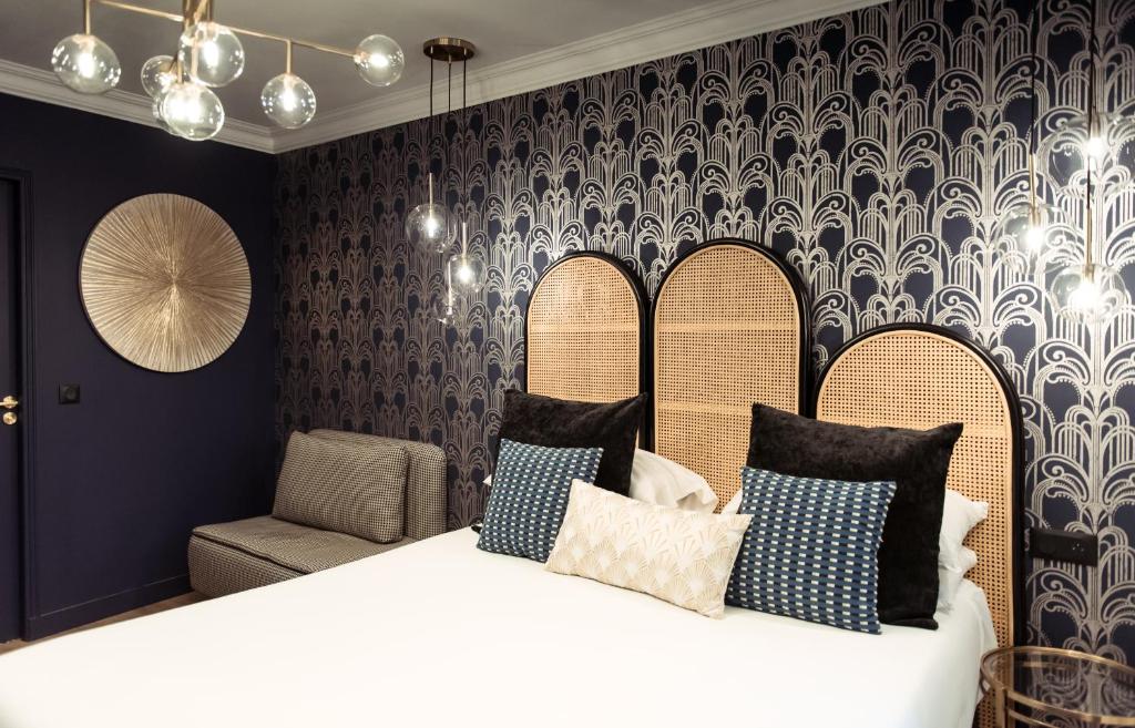 a bedroom with a bed with pillows and a chair at La Caravelle in Aix-en-Provence