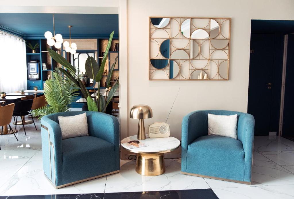 two blue chairs and a table in a room at La Caravelle in Aix-en-Provence
