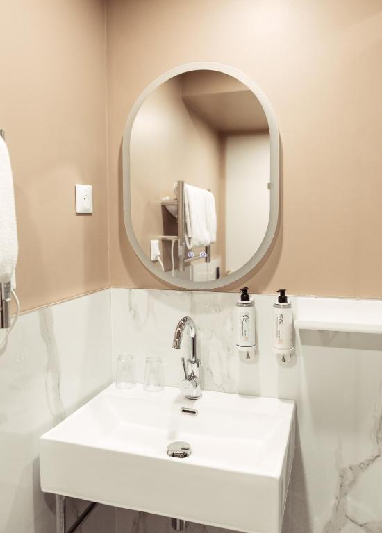 a bathroom with a white sink and a mirror at La Caravelle in Aix-en-Provence