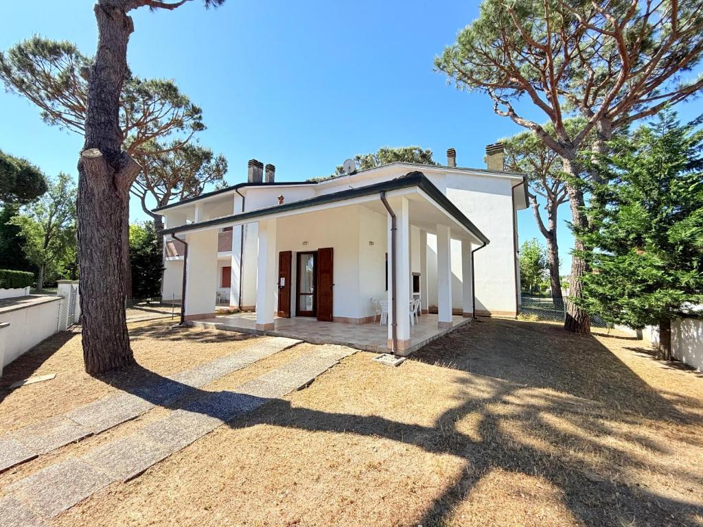a white house with a tree in front of it at Vear apartments - Lido di Volano in Lido di Volano