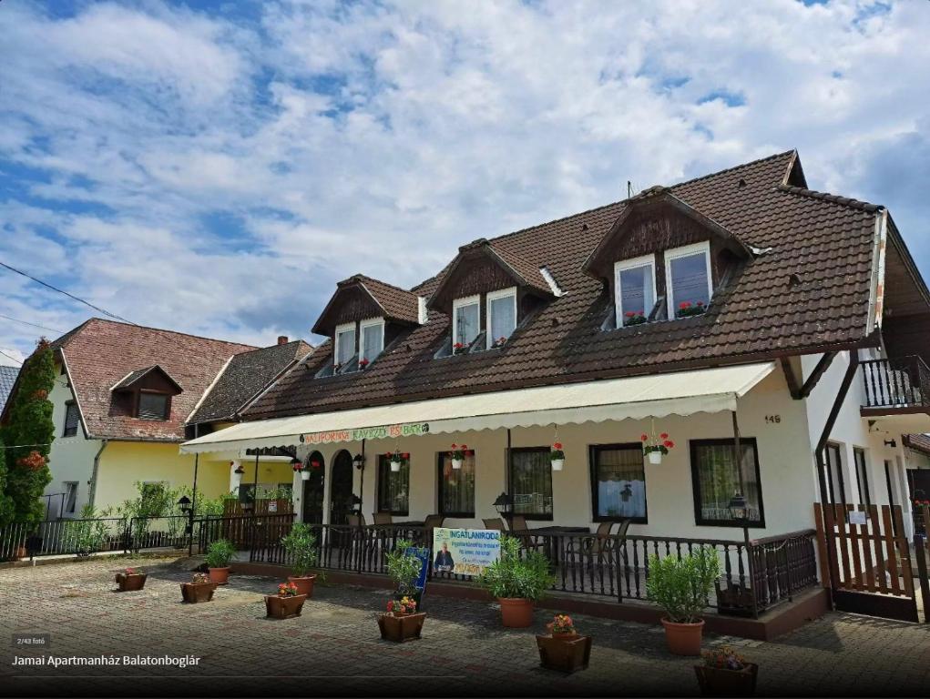 a building with potted plants in front of it at Dózsa Vendégház in Balatonboglár