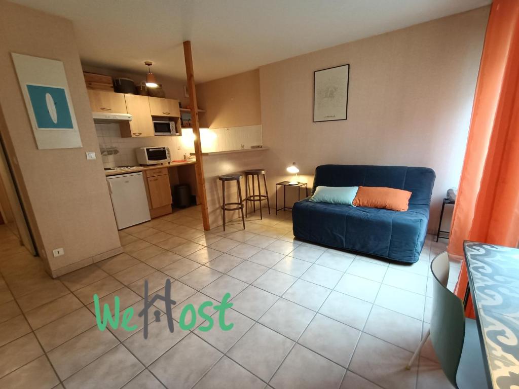 un salon avec un canapé bleu et une cuisine dans l'établissement Studio with Balcony, à La Rochelle