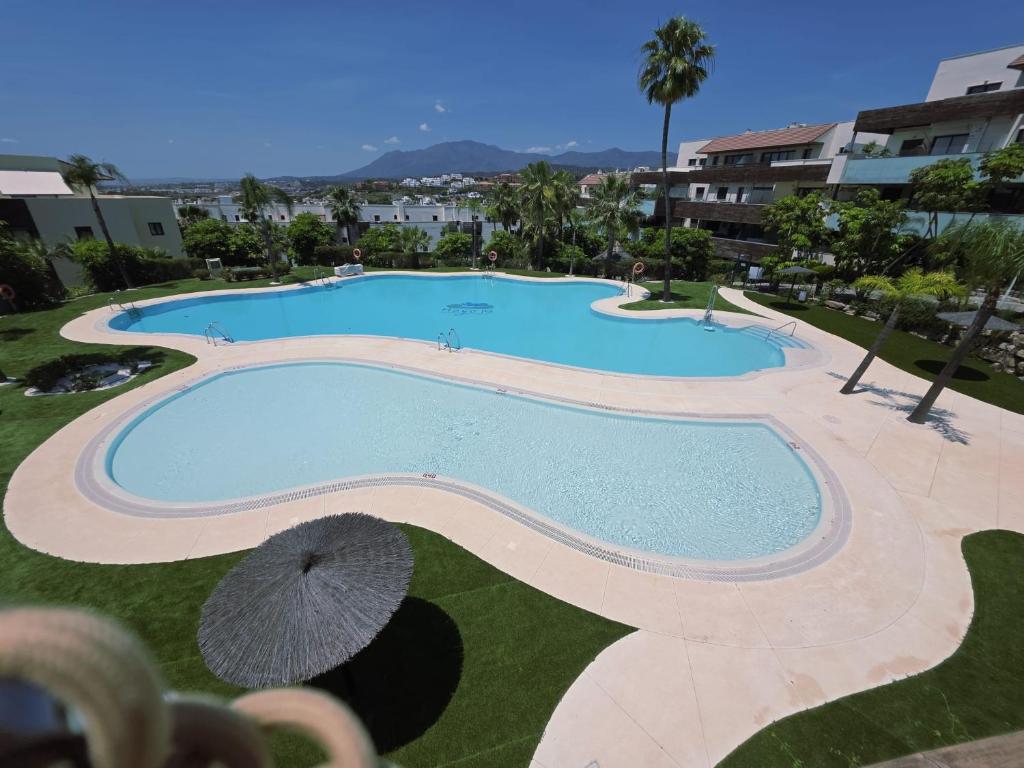 an overhead view of a swimming pool with an umbrella at Los Flamingos Villa Padierna Apartment in Estepona