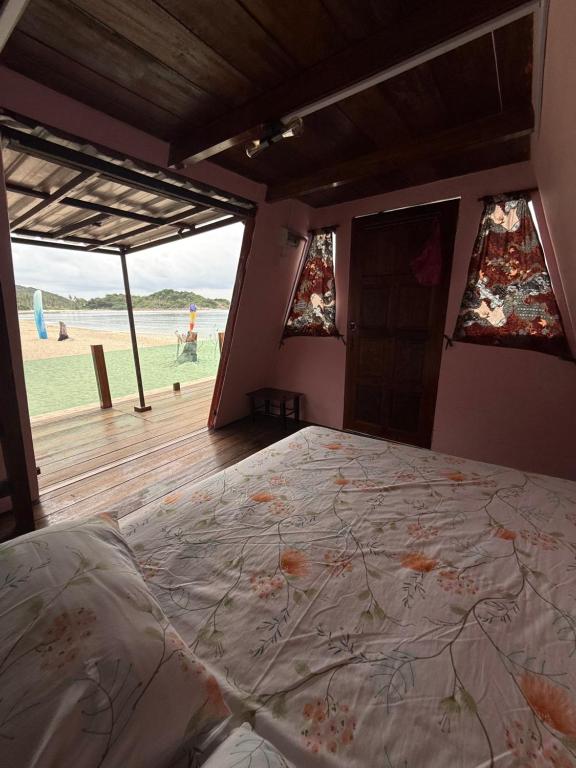 a bedroom with a bed with a view of the beach at Redang Campstay A Frame in Redang Island