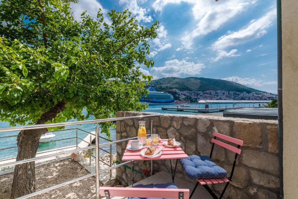 a table and chairs on a balcony with a view of the water at Stylish sea view studio in Dubrovnik