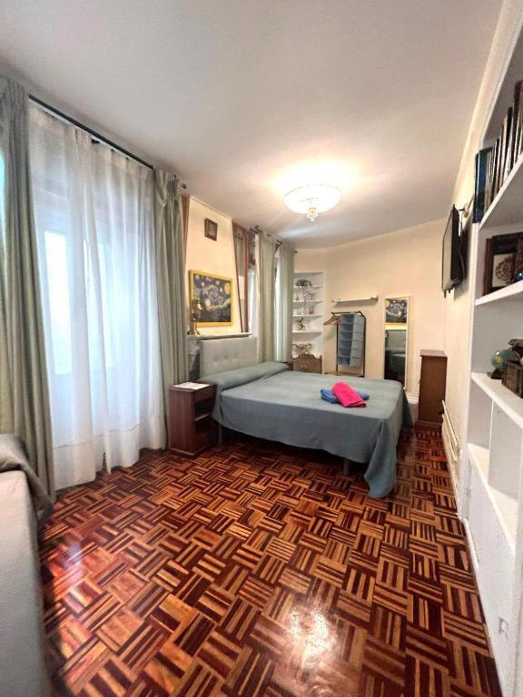 a bedroom with a bed and a wooden floor at Habitaciones en Luisa in Madrid