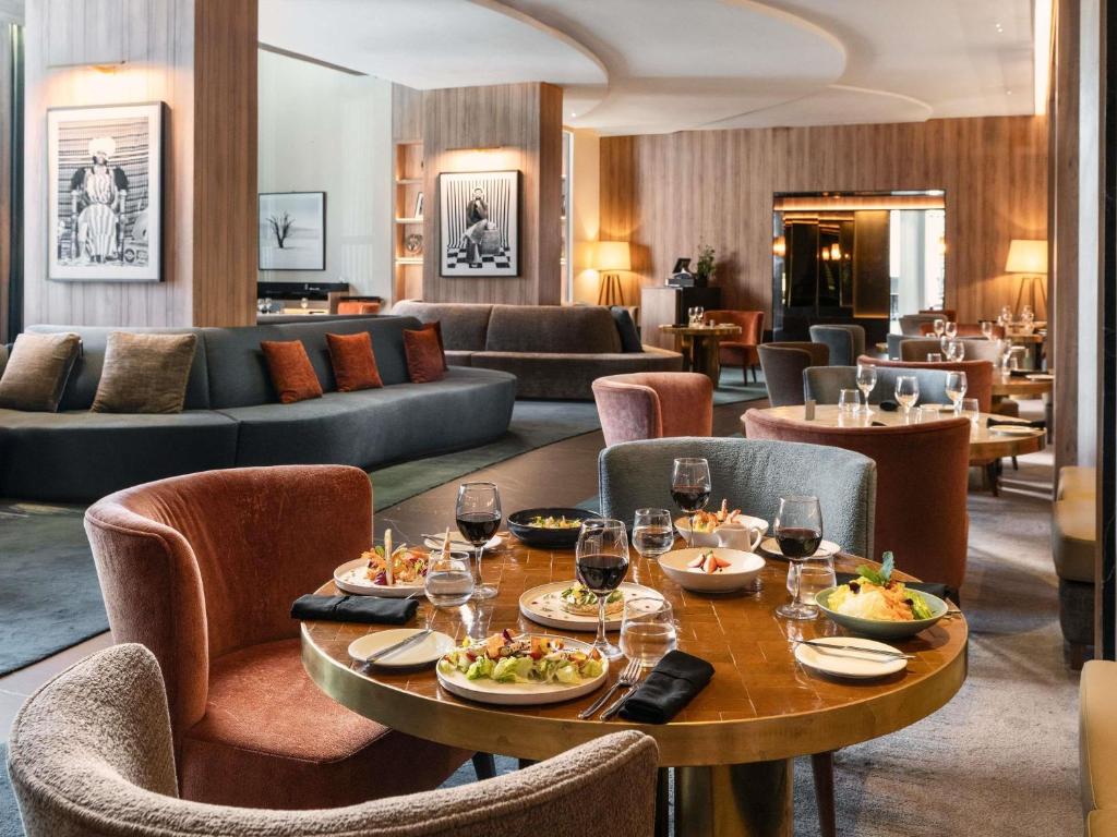 a restaurant with a table with food and wine glasses at Sofitel Casablanca Tour Blanche in Casablanca