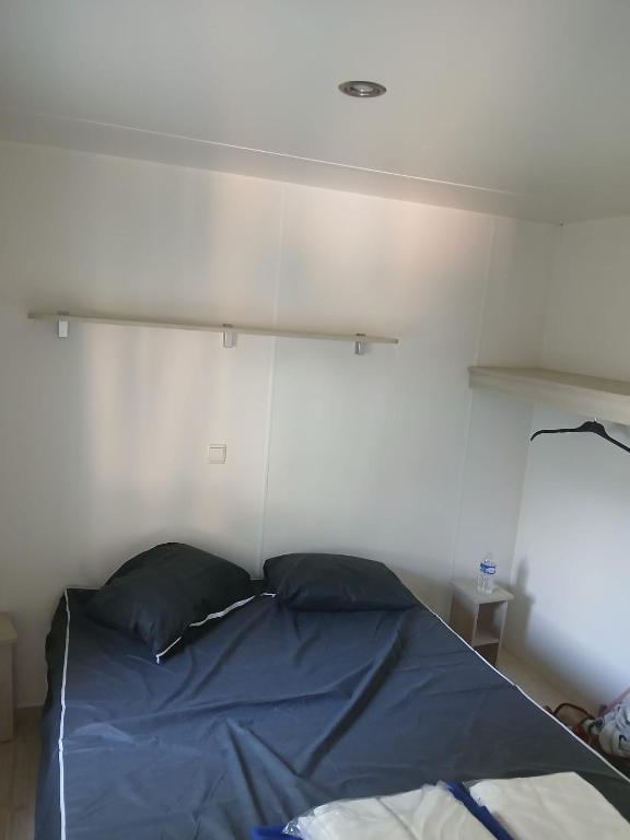- un lit avec 2 oreillers dans une chambre dans l'établissement Mobil Home dans Camping 4 étoiles, à Valras-Plage