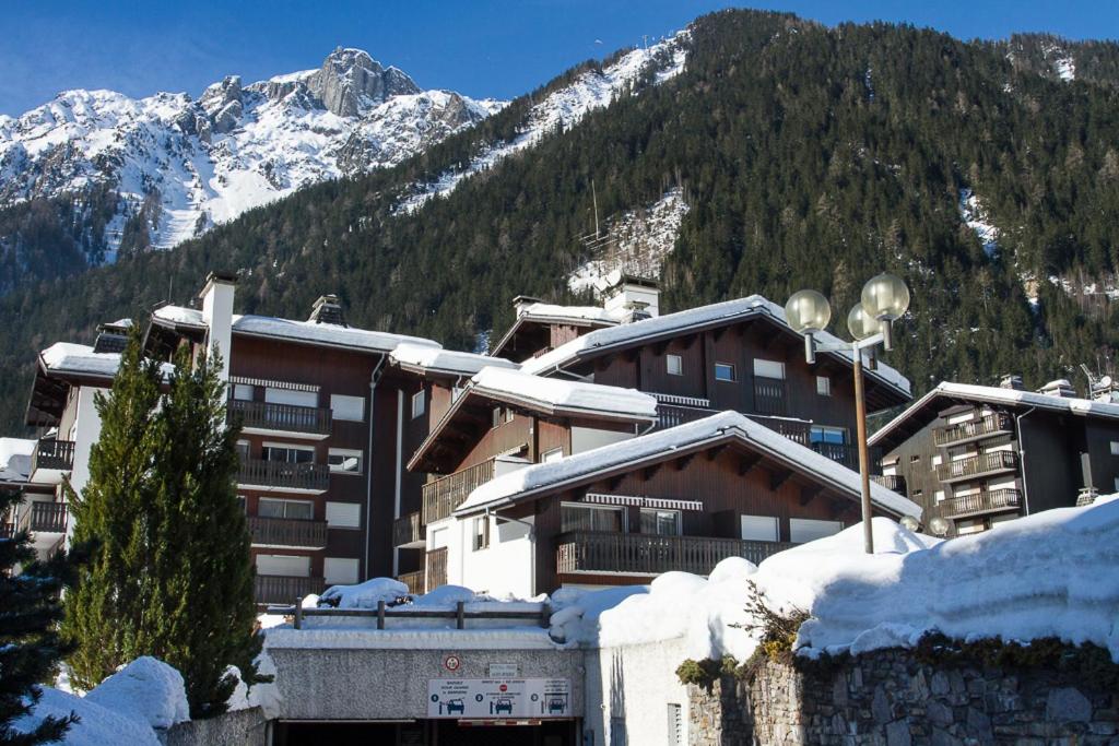 un bâtiment recouvert de neige avec des montagnes en arrière-plan dans l'établissement chamonix centre le clos du savoy, à La Celle-sous-Gouzon