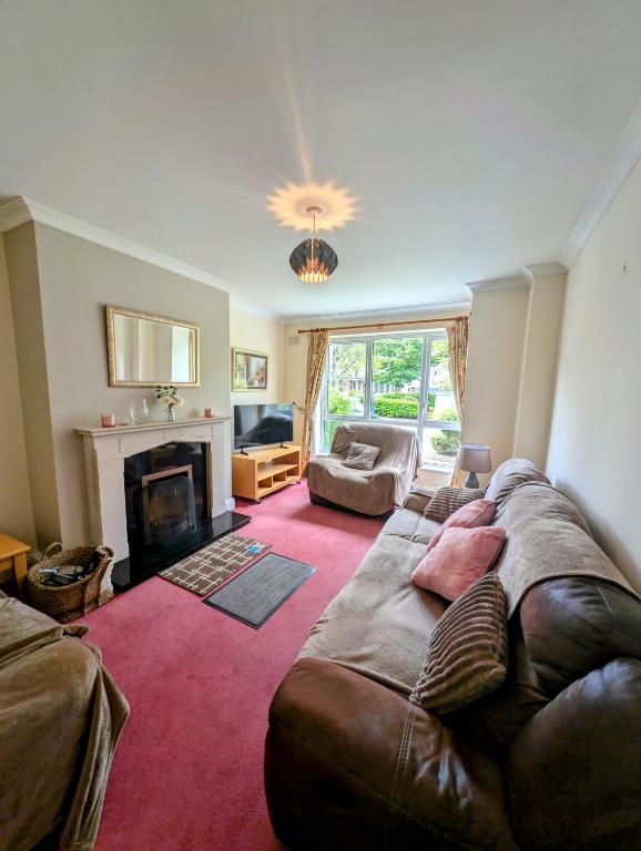 a living room with a large couch and a fireplace at Large 4 Bedroom 5 Bathroom Property in Galway