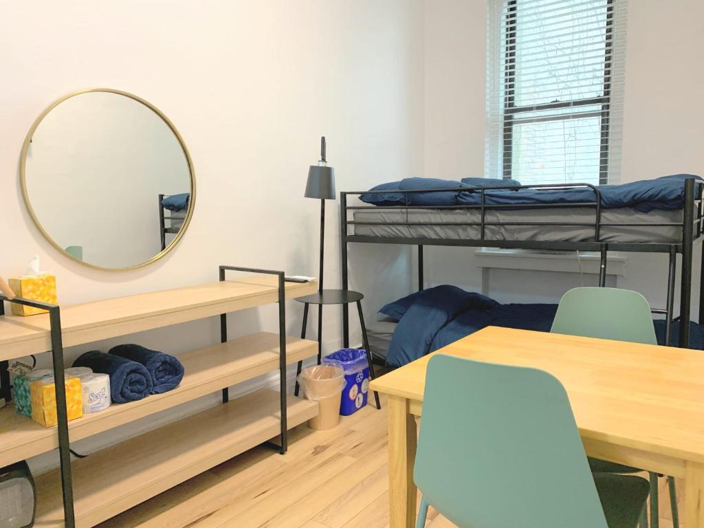 een kamer met een stapelbed, een tafel en een spiegel bij Chelsea Studio-Shared Bathroom with Kitchen Twin Bunk Bed in New York