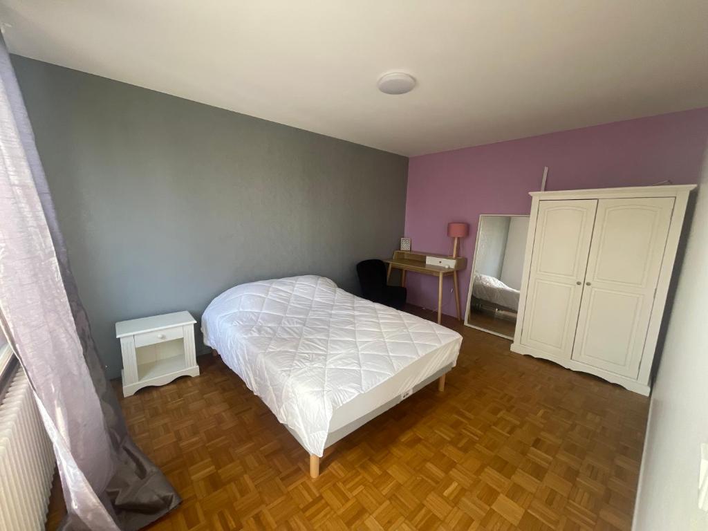 - une chambre avec un lit blanc et des murs violets dans l'établissement Chambre dans coloc filles dans maison avec jardin proche gare RER, Évry-Courcouronnes