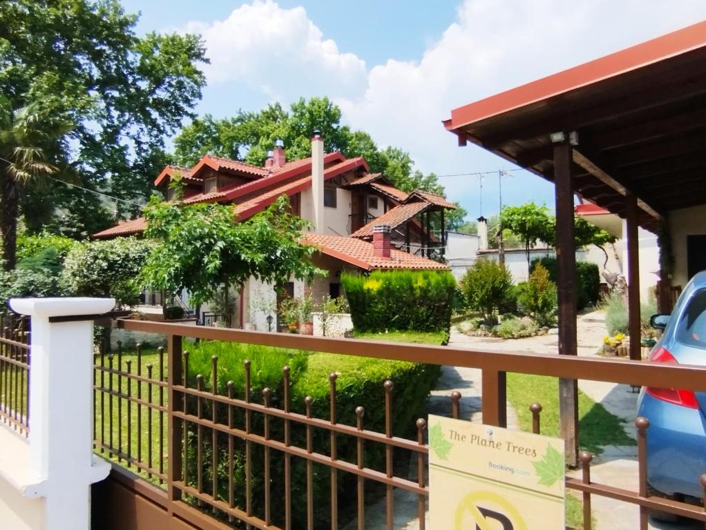 a house with a fence in front of it at "The plane trees" in Polykárpion