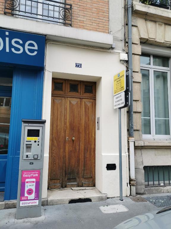 un bâtiment avec une porte en bois et un compteur de stationnement dans l'établissement Chez Sparki - Centre ville REIMS, à Reims