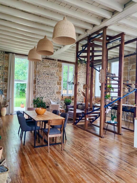 un salon avec une table et des chaises en bois dans l'établissement Maison ancienne école, à Cazères-sur-lʼAdour