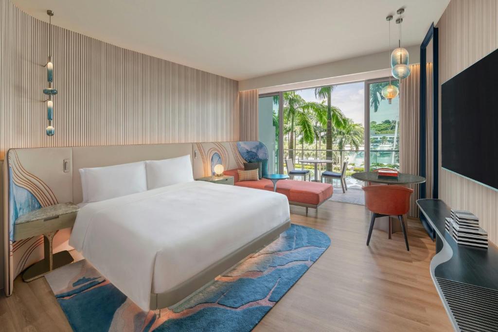 um quarto com uma cama grande e uma sala de estar em W Singapore - Sentosa Cove, Newly Renovated em Singapura