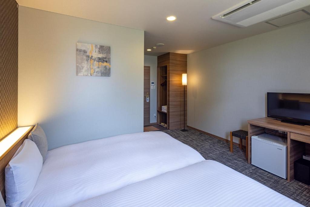 Postel nebo postele na pokoji v ubytování Kiryu Grand Hotel