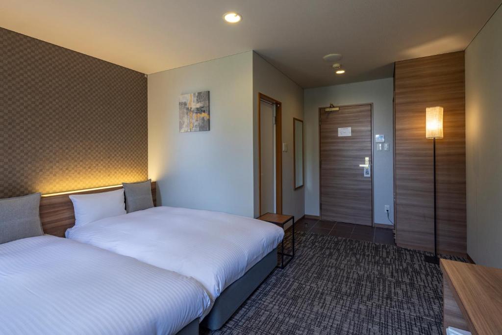Postel nebo postele na pokoji v ubytování Kiryu Grand Hotel