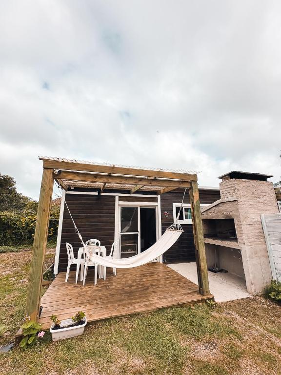 a porch with a swing and a hammock on a house at Brisa del Sur Lofts in La Paloma