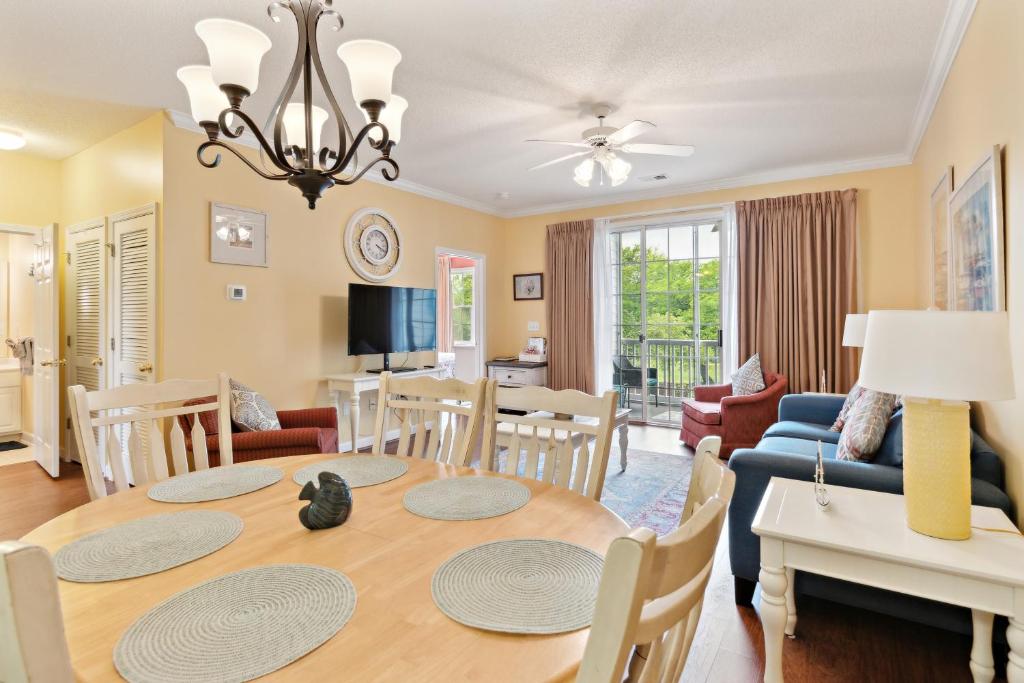 a dining room and living room with a table and chairs at Havens on the Nine condo in North Myrtle Beach