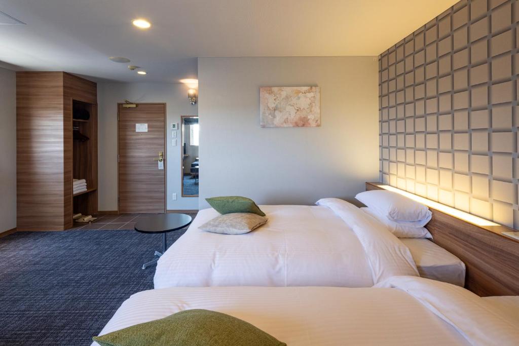Postel nebo postele na pokoji v ubytování Kiryu Grand Hotel