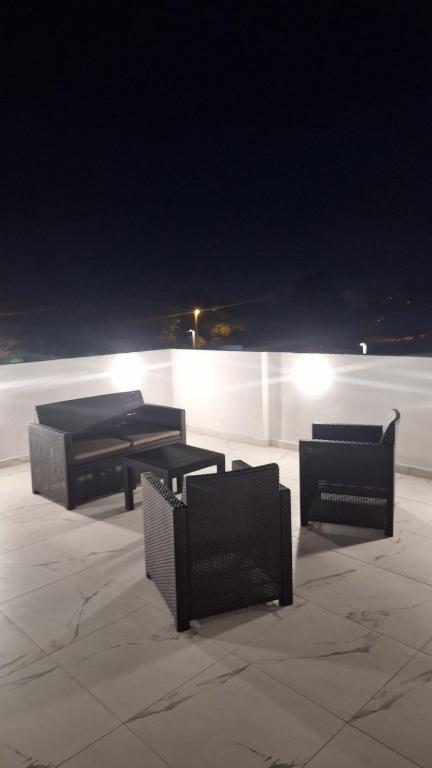 eine Gruppe von Tischen und Stühlen auf einer Terrasse in der Nacht in der Unterkunft Montebello Inn apartments in Ulcinj