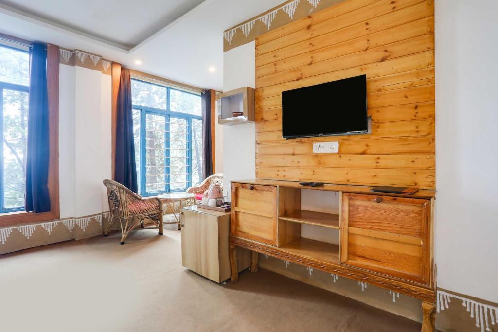 ムスーリーにあるTownhouse Oak Mussoorie Lakeの木製の壁に薄型テレビ付きのリビングルーム