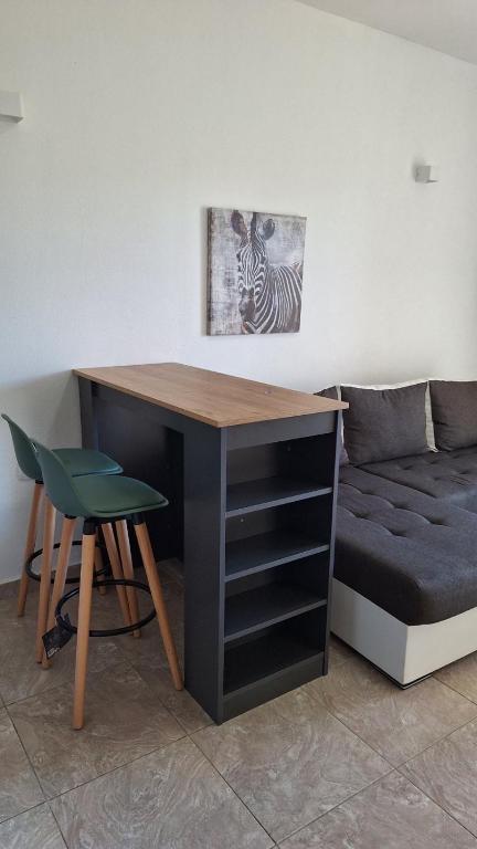 einen Schreibtisch mit einem Stuhl neben einer Couch in der Unterkunft Montebello Inn apartments in Ulcinj