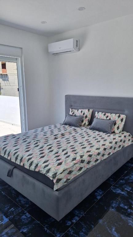 Bett in einem weißen Zimmer mit Bettrahmen in der Unterkunft Montebello Inn apartments in Ulcinj