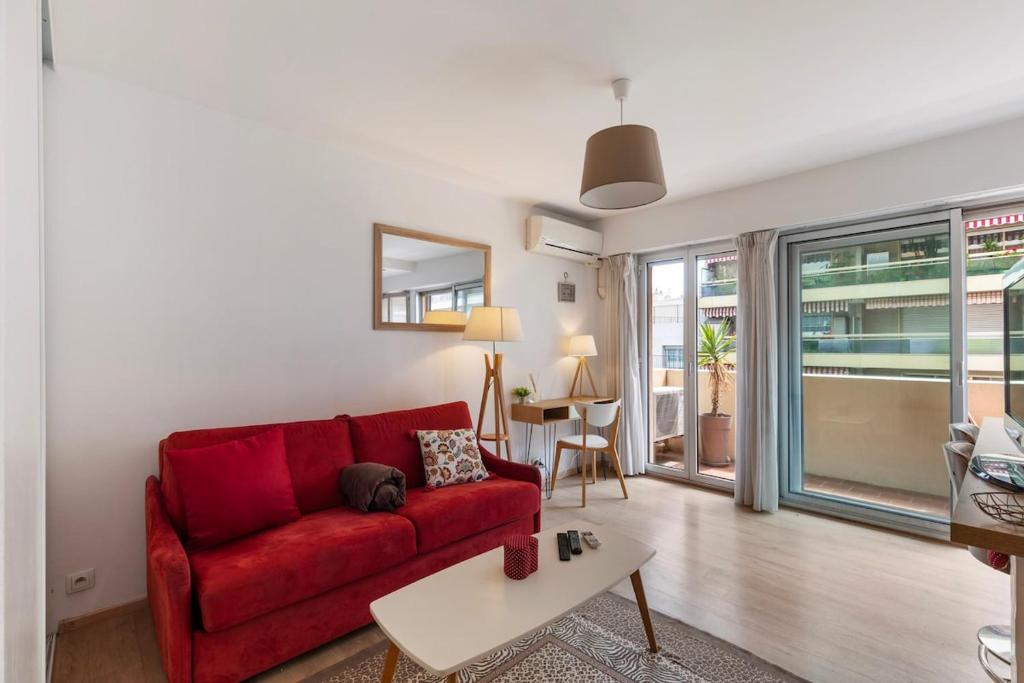 un salon avec un canapé rouge et une table dans l'établissement Studio Wilson - Centre Ville - Terrasse & Parking, à La Celle-sous-Gouzon