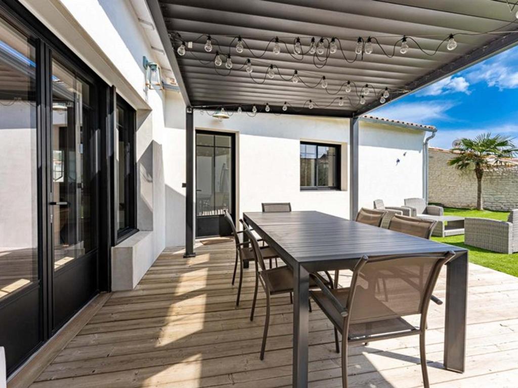 un patio avec une table et des chaises dessus dans l'établissement Maison moderne avec jardin clos pour 4 pers. - FR-1-835-18, au Bois-Plage-en-Ré