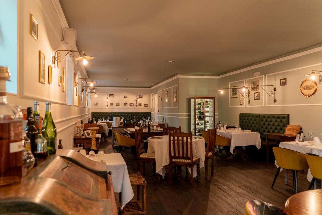 a restaurant with tables and chairs in a room at Locanda Gaudemus Boutique Hotel in Sistiana