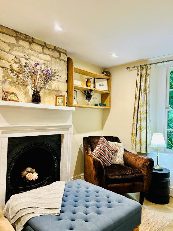 a living room with a fireplace and a chair at Quarry Cottage - Snug Hideaway in Box