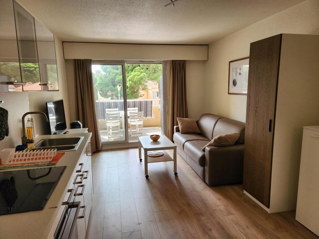 une cuisine et un salon avec un canapé et une table dans l'établissement Entre mer et palmiers, à Hyères