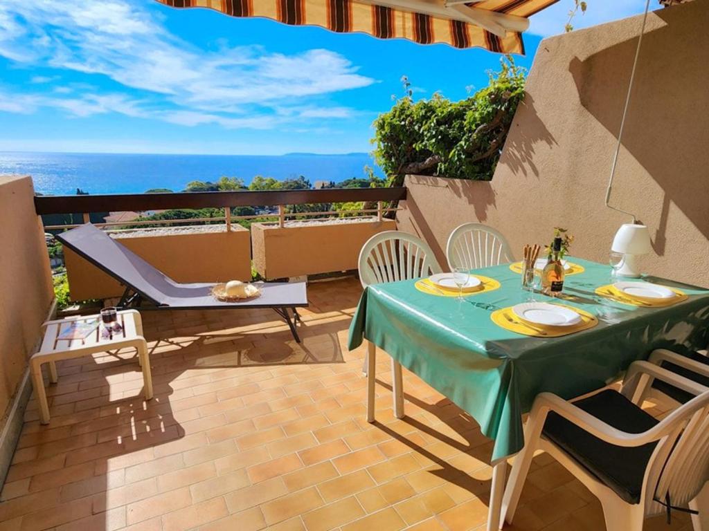 une table et des chaises sur une terrasse avec vue sur l'océan dans l'établissement Le Lavandou T2 pour 4 personnes avec terrasse, vue mer, parking - FR-1-803-36, au Lavandou