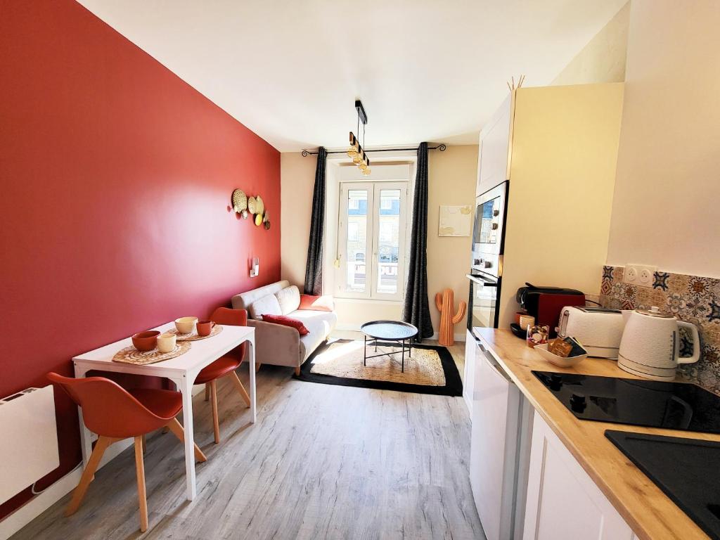 a kitchen and a living room with a table and a kitchen and a couch at Hacienda -A 2 min de la plage in Saint Malo