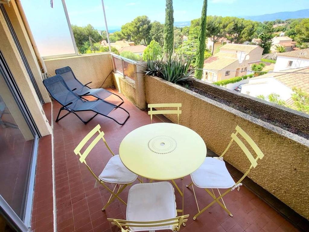 un patio avec une table et des chaises sur un balcon dans l'établissement T1 climatisé avec parking à 700m des plages, animaux admis - FR-1-316-250, à Le Brusc