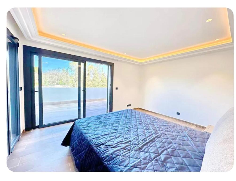 une chambre avec un lit et une grande fenêtre dans l'établissement Villa Riviera, à La Celle-sous-Gouzon