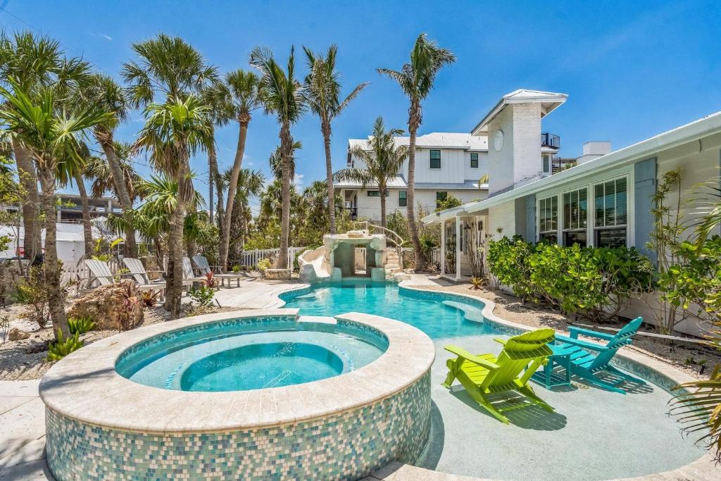 a swimming pool with two chairs and a house at Sunset Splash in Siesta Key