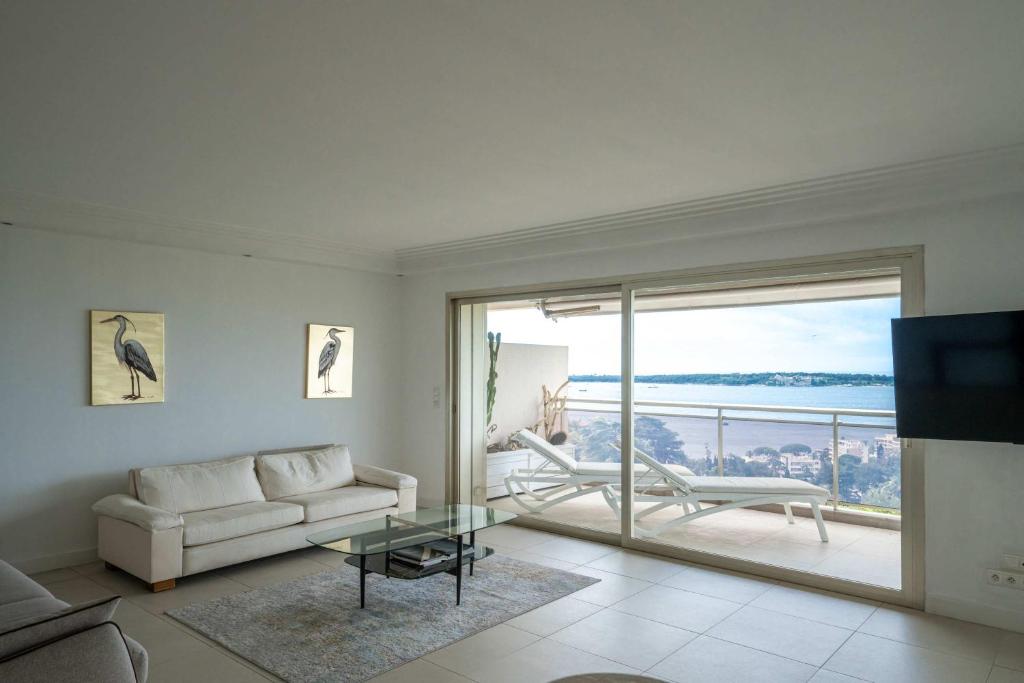 un salon avec un canapé et une grande fenêtre dans l'établissement Appartement vue mer Cannes, à Cannes