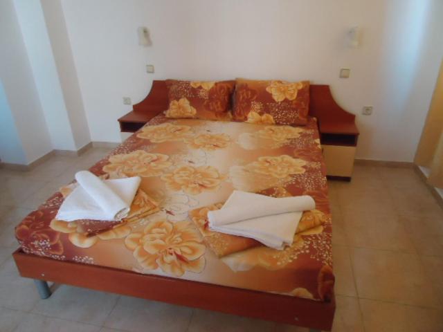 a bed with two pillows on it in a room at Тихия кът in Sozopol