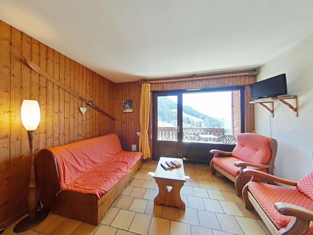 un salon avec un canapé et une table dans l'établissement Grand-Bornand Appt 6 pers. 2 chambres - Navette ski, Cheminée, Ménage inclus - FR-1-241-62, au Grand-Bornand
