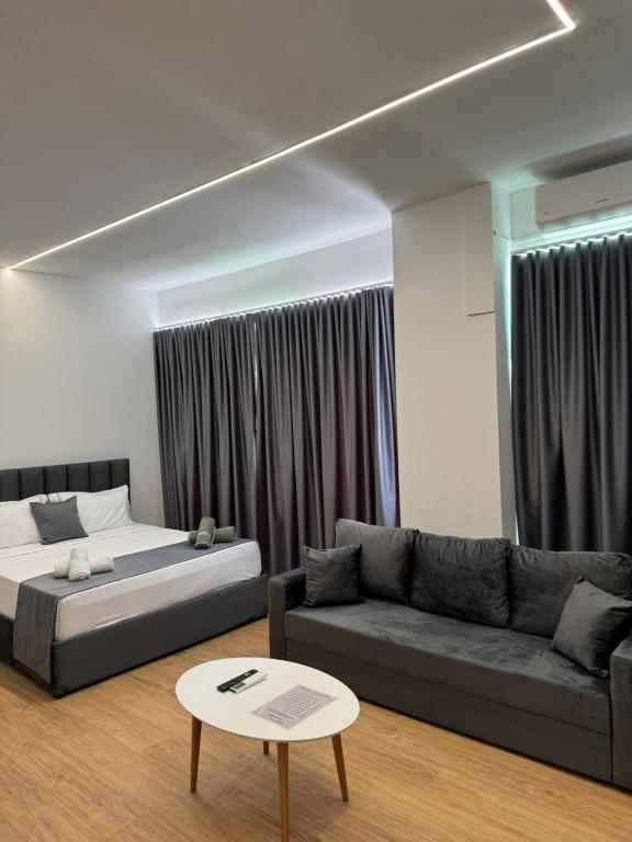 a living room with a bed and a couch at Arber Premium Apartment in Durrës
