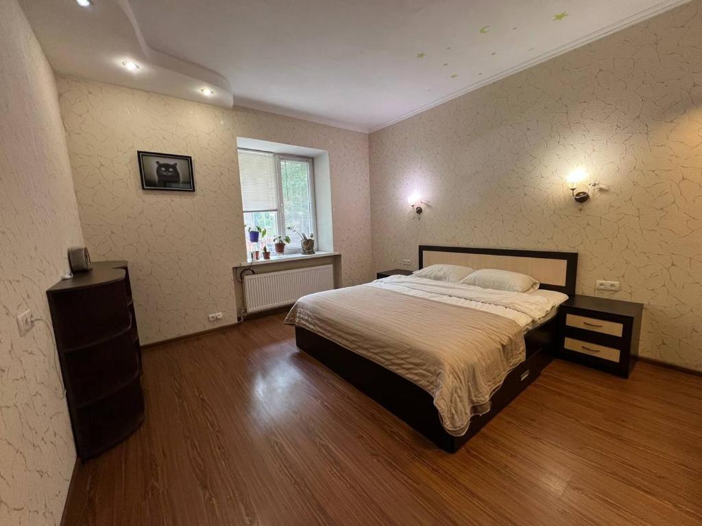 a bedroom with a large bed and a window at Апартаменти Greenhouse in Kropyvnytskyi