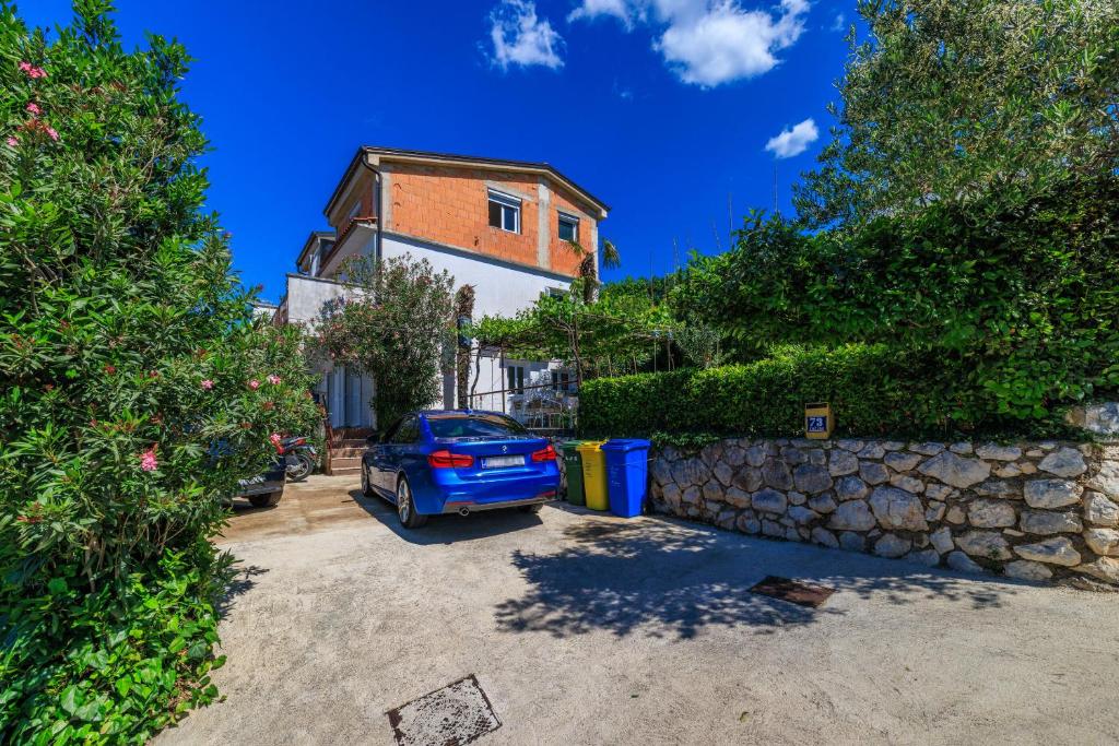 a blue car parked in a driveway in front of a building at Apartments Jadranka in Dramalj